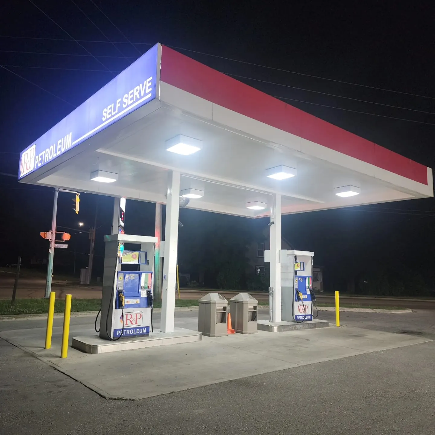 Service station canopy repainted in red and white, lit at night