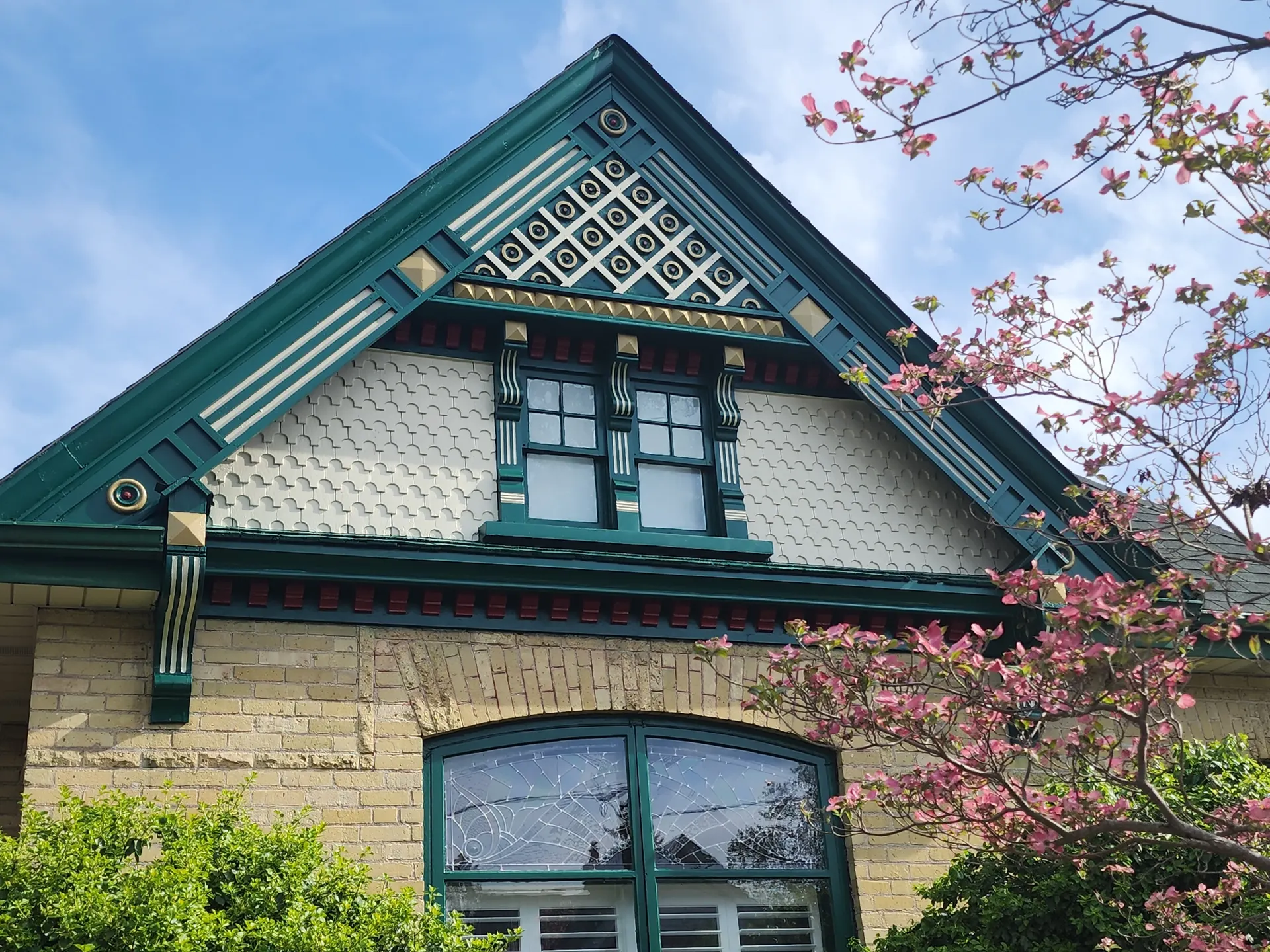 Restored heritage gable with green, cream and gold trim