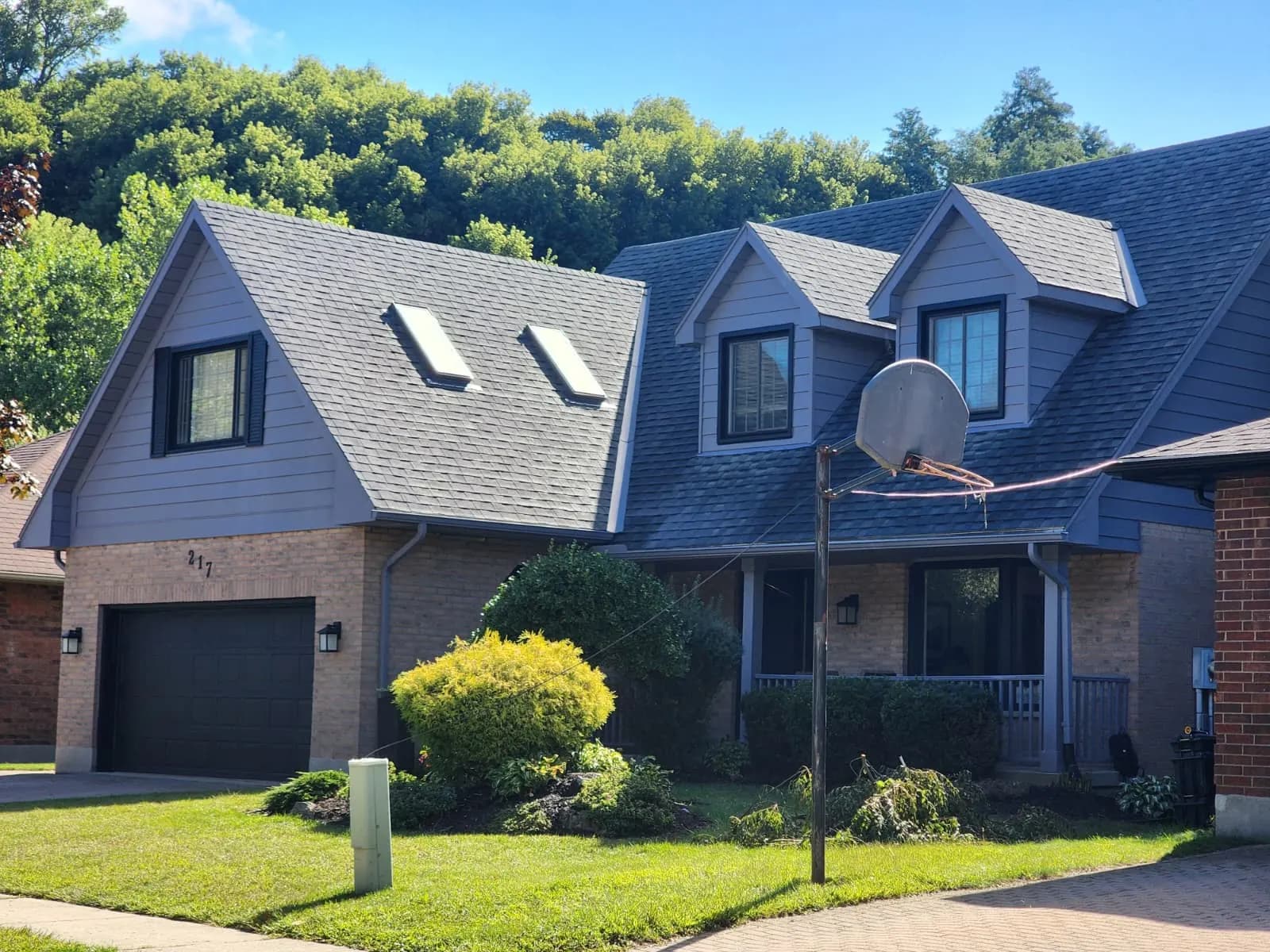 Two-storey house with grey siding and dark garage door