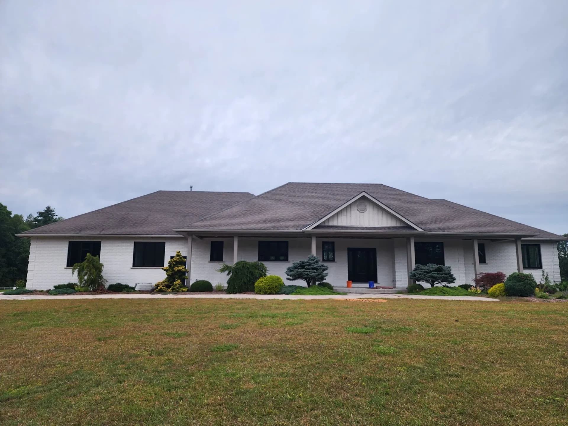 Wide ranch house with white painted brick and dark windows